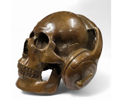 A novelty patinated bronze human skull wearing headphones, 15.5cm high