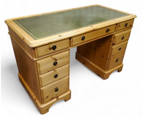 A modern pine twin pedestal kneehole desk with club house green tooled leather writing surface, 77cm x 122cm x 62cm