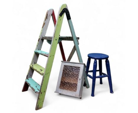 An early 20th century wall cabinet; workshop stool, painted blue; a pair of polychrome painted step ladders, decorative distr