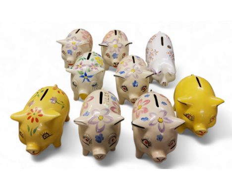 Nine Arthur Wood novelty money boxes, in the form of comical pigs, rotund, standing on all fours,&nbsp; painted with stylised