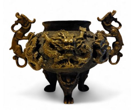 A 19th century Chinese bronze and parcel gilt censer, applied with dragons, three tall feet, 14cm high, six character mark