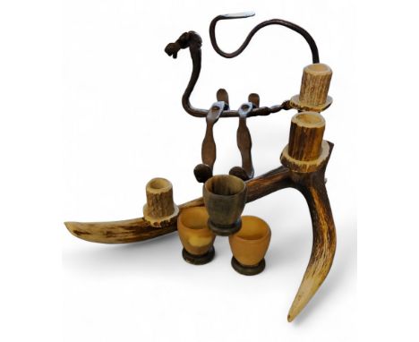 A cast iron fire side sylised dragon, 28cm wide;&nbsp; &nbsp;an antler three light candlesticks;&nbsp; three horn eggcups