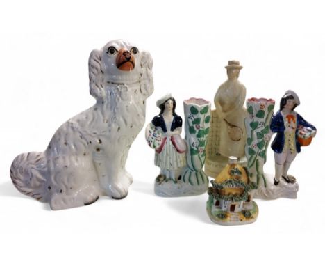 A Staffordshire spaniel, seated to the left, 30cm high,&nbsp; c.1880;&nbsp; &nbsp;a pair of Staffordshire figural spill vases