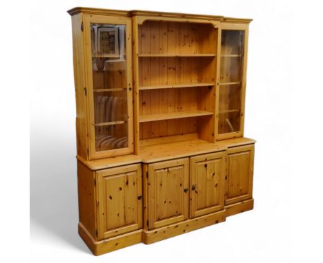 A Ducal Furniture waxed pine breakfront dresser, three shelves to centre flanked by glazed cupboards holding glassinset shelv