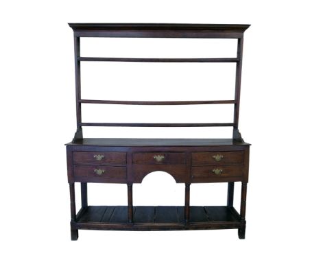 George III oak North Wales dresser, three shelf rack with moulded cornice above base with five drawers, central arch, gun bar