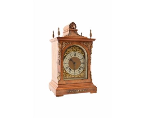An early 20th century German bracket clock. The walnut case has a caddy top pediment with brass acorn finials and brass spand