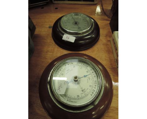A wood frame barometer and thermometer