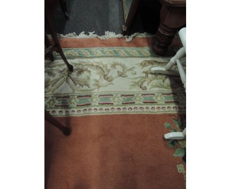 A large carpet square of traditional Indian design, on salmon colour ground