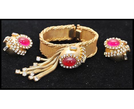 A vintage 1950s Hobé bracelet and earring set consisting of a mesh gold-tone bracelet set with a faux star ruby cabochon surr