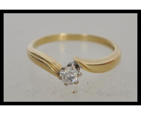 A hallmarked 18ct gold and solitaire crossover diamond ring, prong set with a brilliant cut diamond. Hallmarked Birmingham da