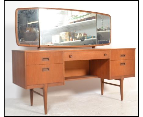 A retro 20th Century kneehole twin pedestal teak wood dressing table,&nbsp;triptych mirror to the top over an arrangement of&