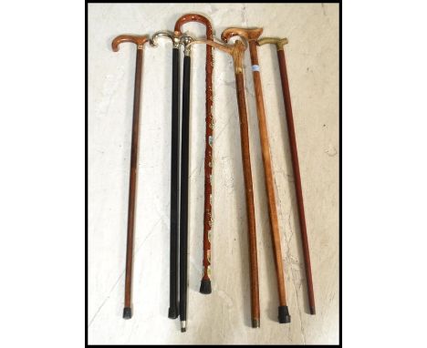 A group of vintage walking stick canes to include horn handled example, one with place crests, silver plated handled etc.