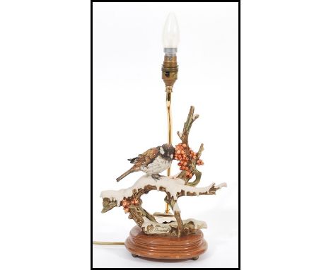 A vintage Capodimonte ceramic table lamp in the form of a bird raised on naturalistic scenery and mounted on plinth base. Blu