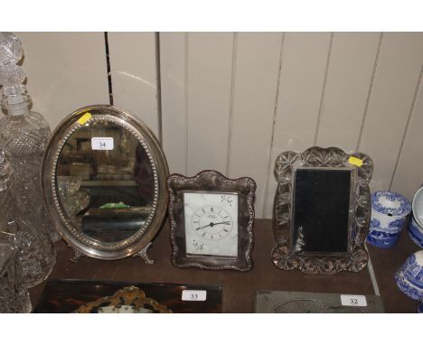 A white metal mounted easel framed mirror; a Waterford photo frame; and a silver mounted Carr mantel clock