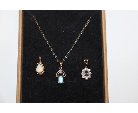 A 9ct gold opal pendant; similar blue topaz and diamond pendant; another blue topaz and cubic zirconia pendant with fine gold