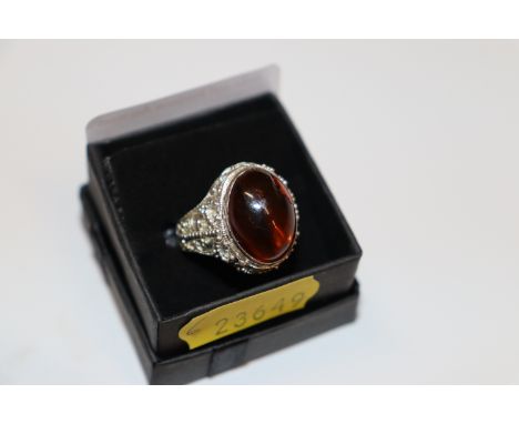 A large one size sterling silver and treacle amber dress ring