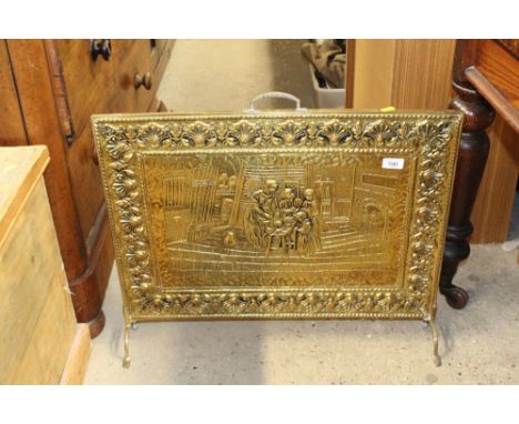 A brass embossed fire screen decorated with interior scene 