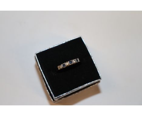 A yellow metal ring set with blue and white stones