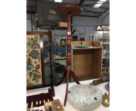 A tall dark wood stained tripod wine table