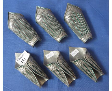 Six Persian style chased white metal and green enamel napkin rings. (6)