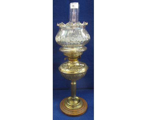 Early 20th Century brass double burner oil lamp with brass repousse reservoir and column on a turned wooden base.  wrythen ba