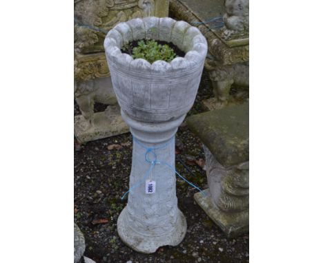 A COMPOSITE COOPERED EFFECT PLANTER, on a separate plinth, diameter 30cm x height 81cm