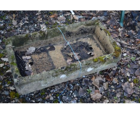 A RECTANGULAR RECONSTITUTED STONE TROUGH raised on twin supports, width 83cm x depth 47cm x height 19cm
