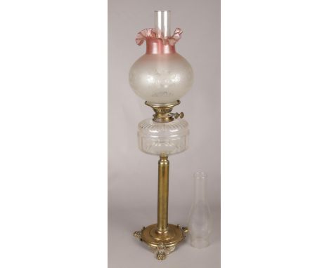 A large Victorian brass oil lamp, with decorative frill top glass shade and spare funnel.  