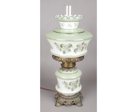 A brass electric converted oil lamp with green and white glass shade.  