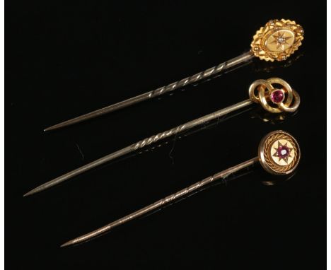 Three 15ct gold stick pins. Two set with single ruby stones, the other set with a diamond.  