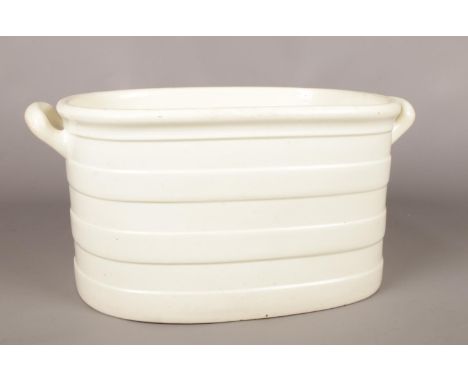 A 19th century Don Pottery creamware foot bath. Lug handles and banded details. (39cm x 26cm)  Two chips to base edge.