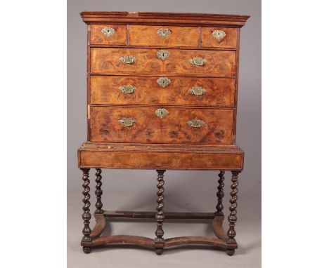 An early Georgian walnut oyster veneered chest on stand. Raised on five barley twist supports, with stretcher and bun feet. 1
