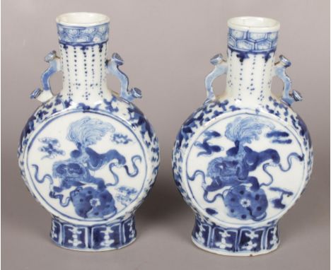 A pair of 19th century Kangxi blue and white moon flasks. Decorated with temple lions. 21cm.  