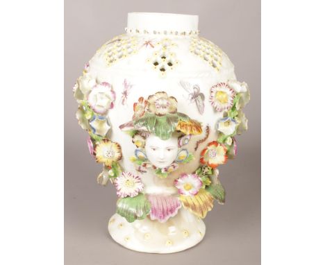 An 18th century Derby porcelain vase with pierced neck, decorated with two masks, painted insects and applied floral bocage. 