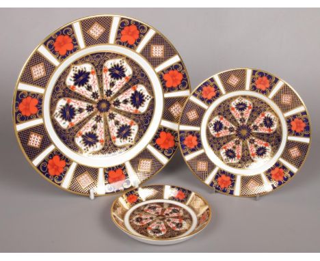 Two Royal Crown Derby plates in the Imari pattern along with a matching trinket dish. (22cm, 16cm and 11cm).  No chips, crack