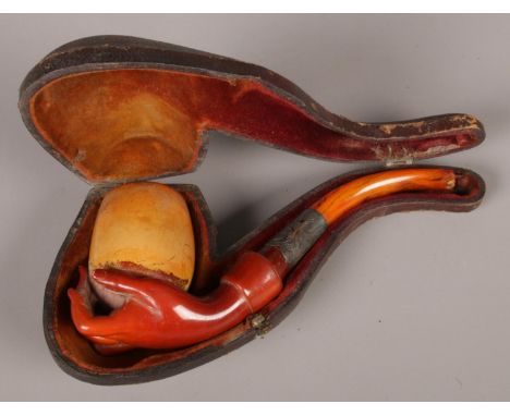 A 19th century cased meerschaum pipe formed as a hand holding the bowl. With amber stem.  