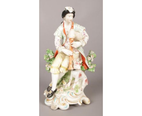 An 18th century Derby porcelain figure, modelled as bagpipe player with a dog. 18.5cm.  Repair to bag pipe, ear of dog and co