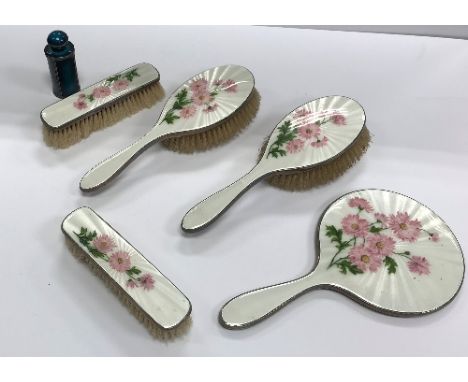 A silver and enamel backed engine-turned dressing table set comprising mirror, two clothes brushes and two hairbrushes, the b