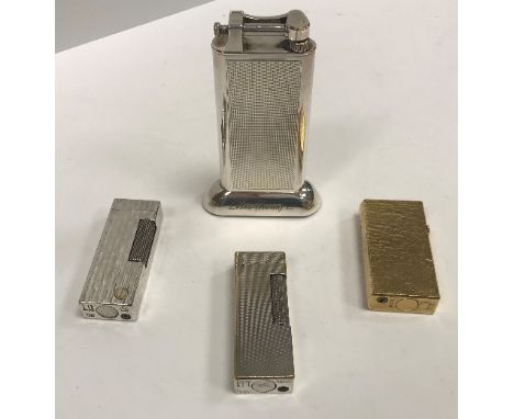 A collection of four various Dunhill lighters including an engine-turned table lighter inscribed "Ellis Kens Ltd", 10 cm high