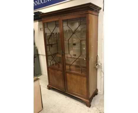 An Edwardian mahogany and inlaid display cabinet, the moulded and parquetry inlaid cornice over two astragal glazed doors enc