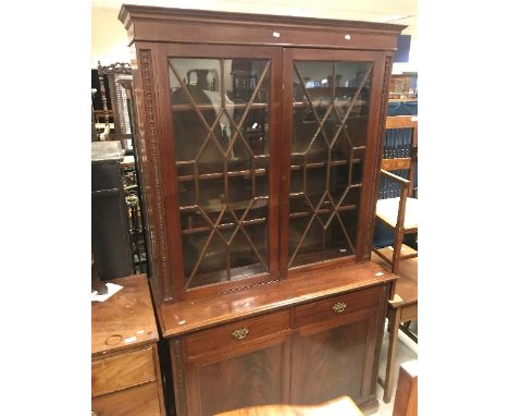 An Edwardian mahogany bookcase cabinet, the upper section with astragal glazed doors enclosing three shelves flanked by hareb