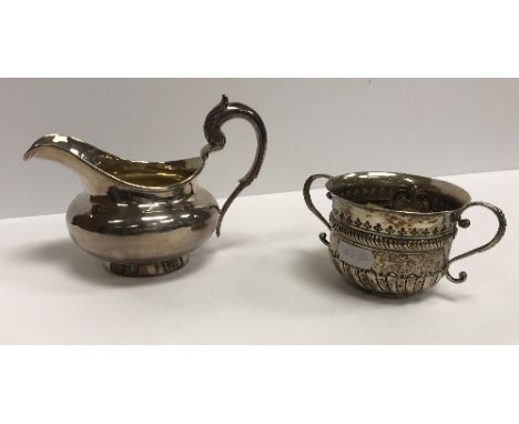A William IV silver cream jug of bellied form with acanthus thumbpiece to the C scroll handle, raised on a splayed circular f