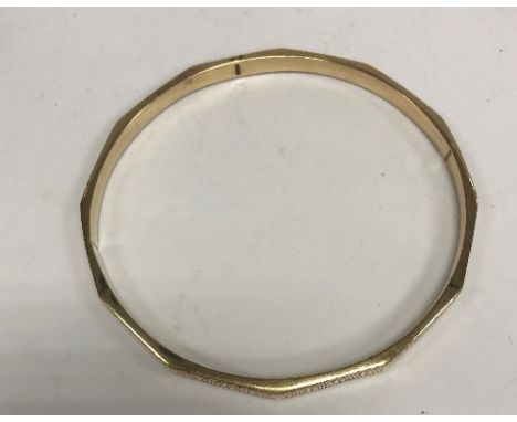 A 9 carat gold bangle of dodecagon form with Greek key design, 6.9 cm inner diameter, 8.9 g