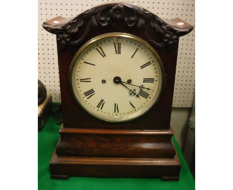 An early Victorian mahogany cased mantel clock with oak leaf and acorn decorated cornice over the painted dial with Roman num