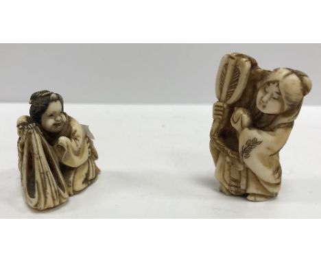 A 19th Century Japanese Meiji period carved ivory netsuke as a mother and child, she kneeling before a blanket, signed with t