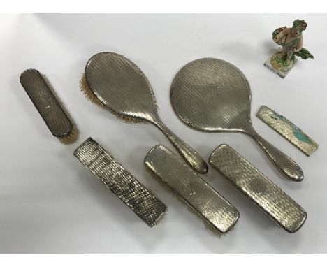 A George V silver and engine turned four piece dressing table set comprising two clothes brushes, hairbrush and mirror (by As