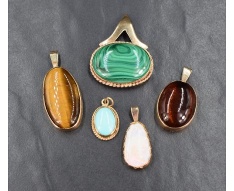An assortment of semi-precious cabochon pendants, all set in yellow metal having no marks, including tiger's-eye, amber and o