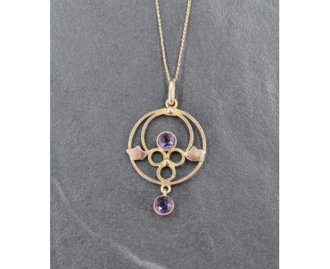 An Edwardian style yellow metal pendant and chain stamped 9ct having amethyst decoration in a circular form, chain length app