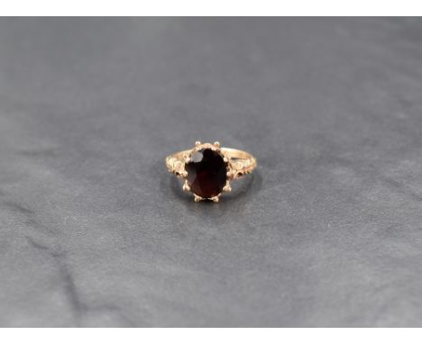 An oval garnet ring in a claw set moulded mount on a 9ct gold loop, size J &amp; approx 3g