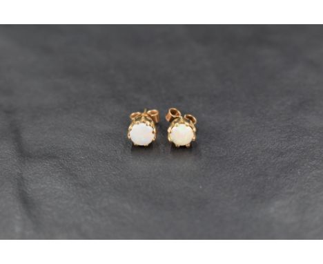 A pair of 9ct gold opal stud earrings, the opals in an eight claw setting with yellow metal butterfly backs, 1.1g gross
